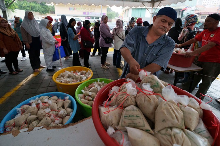 Volonteri dijele hranu u svetom mjesecu Ramazanu u džamiji u Kuala Lumpuru u Maleziji. Tokom mjeseca Ramazana, džamija kuha i dijeli hiljade obroka dnevno. 
FOTO: AP/Tanjug
