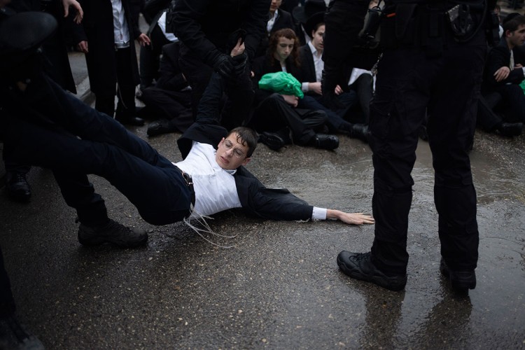 Izraelski policajci u sukobu sa ultraordoksnim Jevrejima tokom protesta protiv potencijalnog novog zakona koji bi mogao da okonča njihovo oslobađanje od vojne službe u Jerusalimu. 
FOTO: AP/Tanjug 
