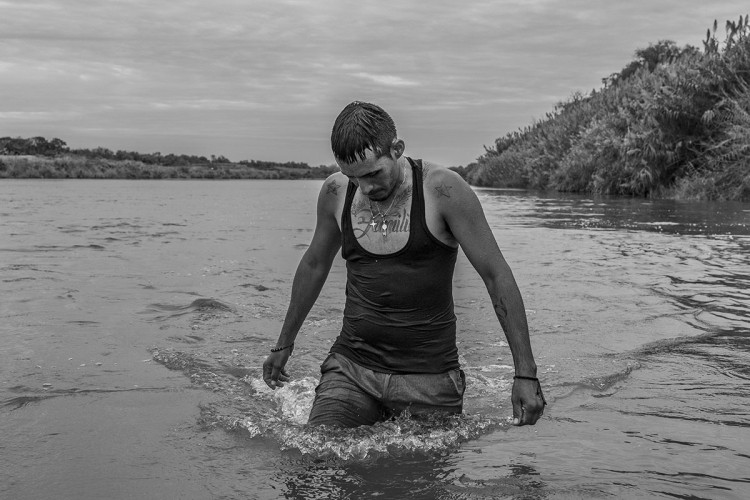 Na fotografiji je Karlos Mendoza, venecuealanski migrant koji prelazi rijeku kako bi došao u poziciju da zatraži azil u SAD-u. 