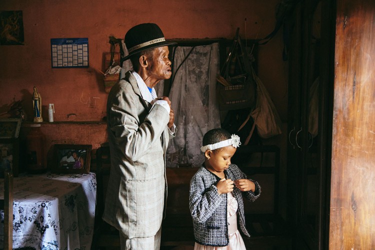 Fotografija prikazuje Dadu Paula (91) koji živi sa demencijom i njegovu unuku (5) u kući u Madagaskaru kako se spremaju za crkvu u nedjelju ujutro