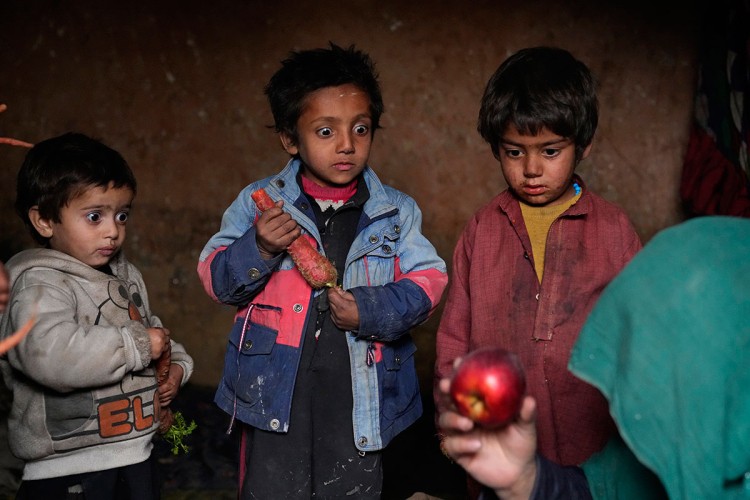 Od haotičnog talibanskog preuzimanja Kabula 15. avgusta 2021. ionako ratom razorena ekonomija koja je nekada bila na životu samo zahvaljujući međunarodnim donacijama sada je na rubu kolapsa. Nema dovoljno novca za bolnice. Svjetska zdravstvena organizacija upozorava na milione djece koja pate od pothranjenosti, a UN. kaže da će 97% Avganistanaca uskoro živjeti ispod granice siromaštva. Troje avganistanske interno raseljene djece iznenađeno gleda u jabuku koju je njihova majka donijela kući nakon prosjačenja, u kampu na periferiji Kabula